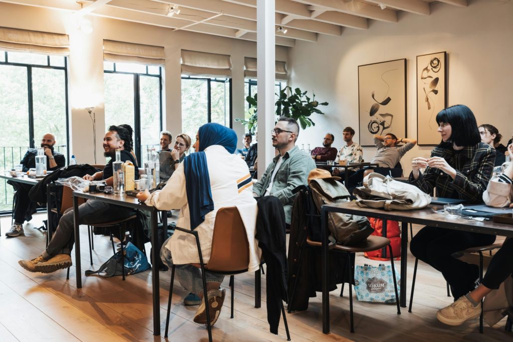 Un groupe diversifié d'adultes participant à un séminaire interactif dans un espace intérieur moderne et bien éclairé.